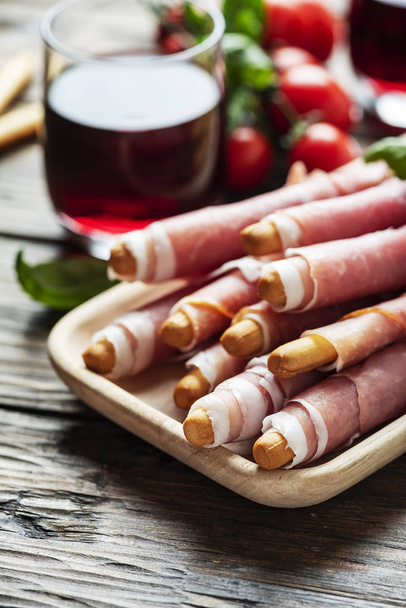 Italian antipasto with brad sticks and pork ham - Фото, зображення