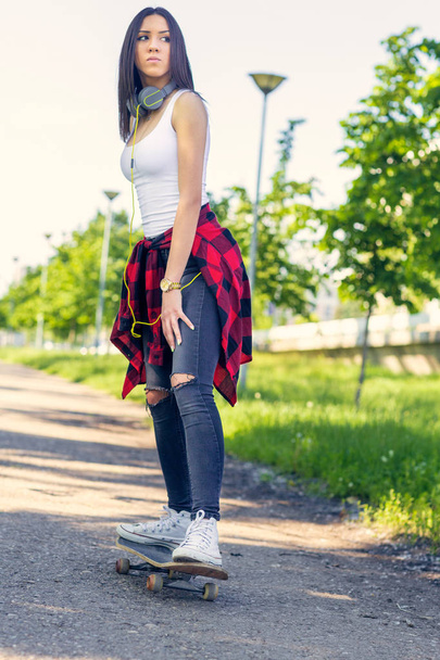 Girl skateboarder - sporty legs skateboarding in park - Fotó, kép