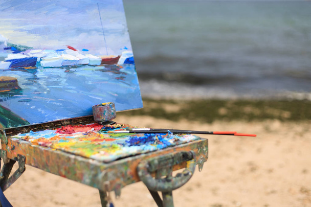 Açık havada fırçalar ve yağlı boyalar ile sanatçının renkli işyeri - Fotoğraf, Görsel