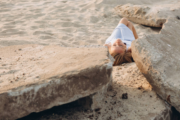 woman lying sand stones foreground - Фото, зображення
