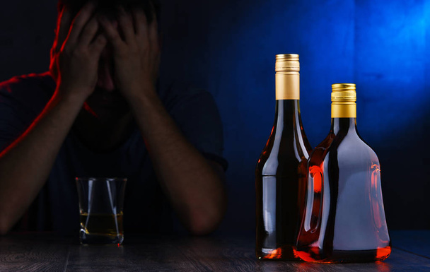 Μπουκάλια με αλκοολούχα ποτά και τη μορφή ενός μεθυσμένου - Φωτογραφία, εικόνα