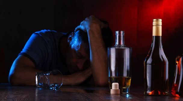 Flaschen mit alkoholischen Getränken und die Figur eines Betrunkenen - Foto, Bild