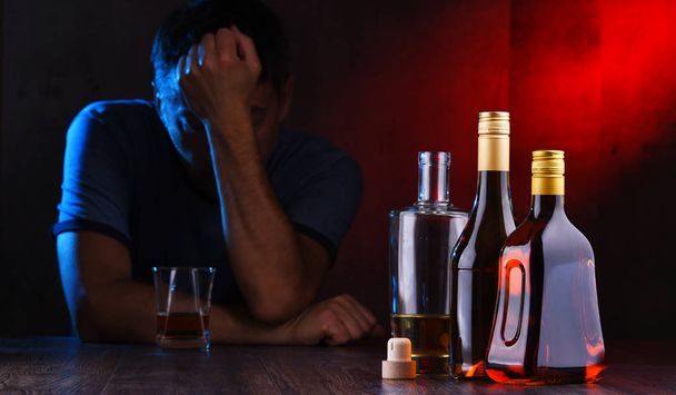 Μπουκάλια με αλκοολούχα ποτά και τη μορφή ενός μεθυσμένου - Φωτογραφία, εικόνα