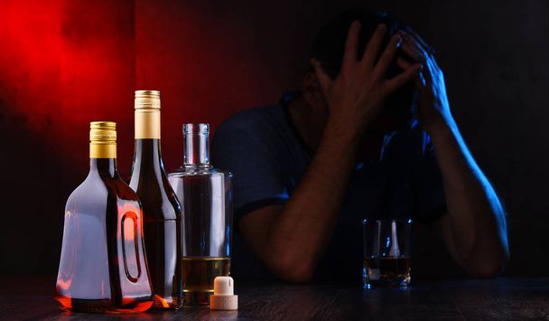 Бутылки с алкогольными напитками и фигура пьяного мужчины - Фото, изображение
