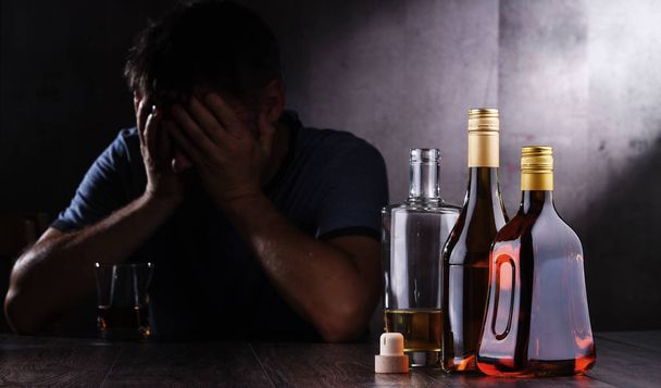 Butelki z napojami alkoholowymi i postacią pijanego człowieka - Zdjęcie, obraz