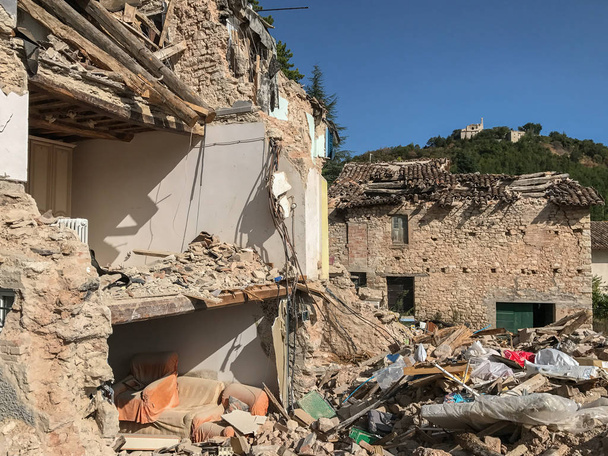 Сильно поврежденный дом в сельской местности Италии после землетрясения, наружная стена была разрушена, обнажая внутреннюю часть дома
. - Фото, изображение