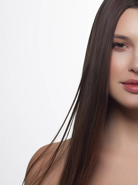 Close-up of beauty girl with long straight developing hair and radiant daytime makeup on her face. Skin care natural cosmetics in the spa salon or cosmetology. - Foto, Bild