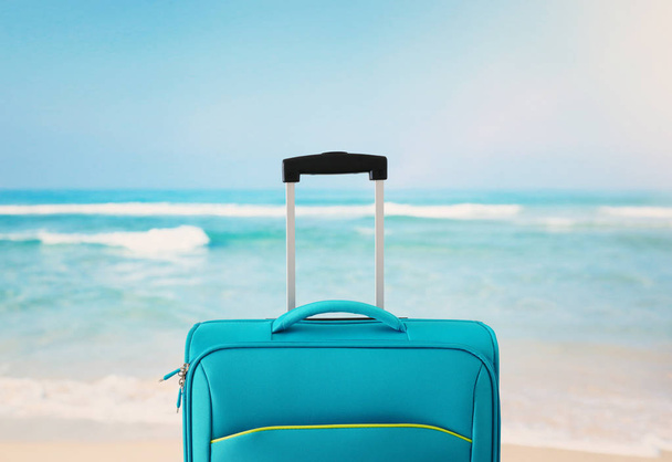holidays. travel concept. blue suitcase infront of tropical background - Φωτογραφία, εικόνα