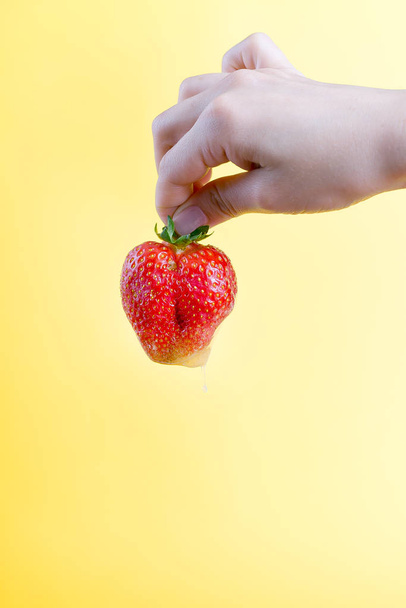 Large red strawberry on bright yellow warm background - Φωτογραφία, εικόνα