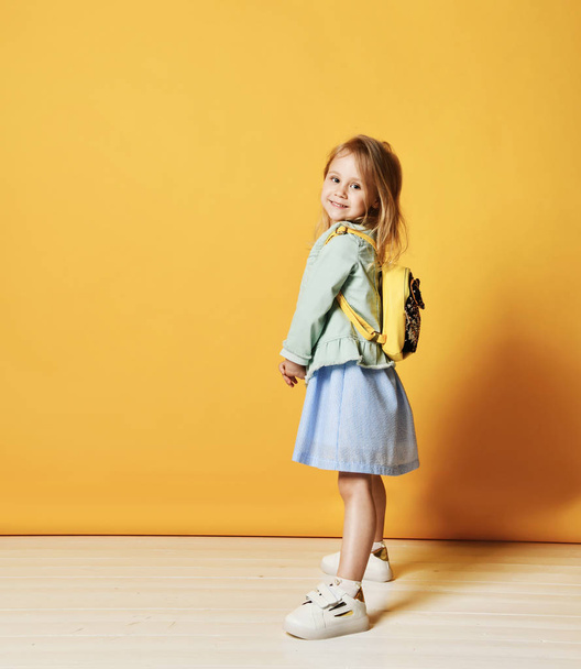 Full length portrait of a cute little child girl in a stylish dress and denim. - Foto, Imagen