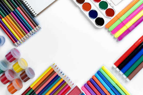 Back to school concept. School equipment with colored pencils, gouache, watercolor, plasticine and notepad on white background. Flat lay, top view, copy space. - Photo, Image