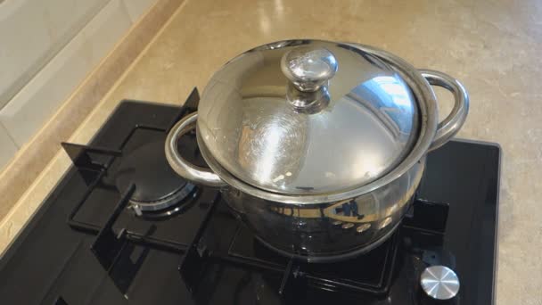 water kookt in de stalen pan met deksel op een gaskachel - Video
