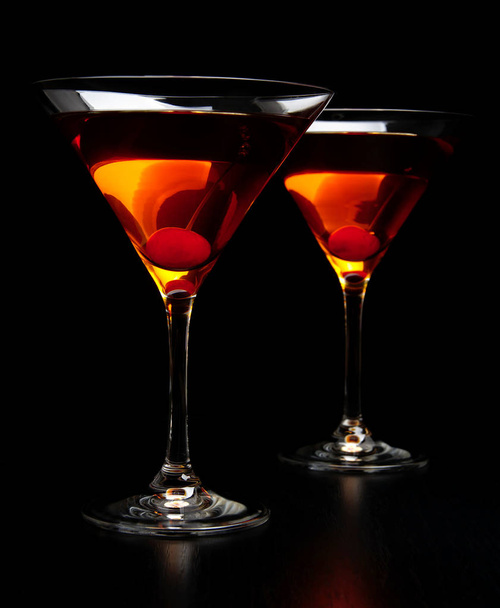 Manhattan drinks with red cherry on black - Fotó, kép