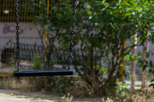 Los niños se balancean con una cadena en un parque infantil
. - Foto, Imagen