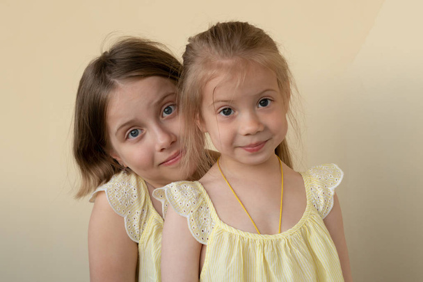 ritratti di due bambine in piedi in abiti gialli
 - Foto, immagini