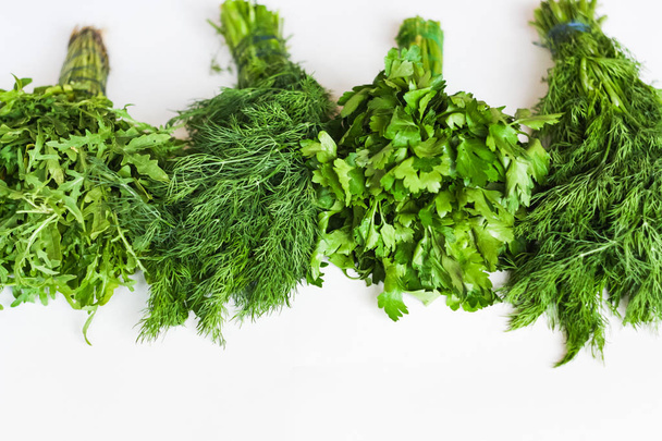 Different bunches of organic greens/herb: arugula, parsley, dill isolated on white background - Photo, Image
