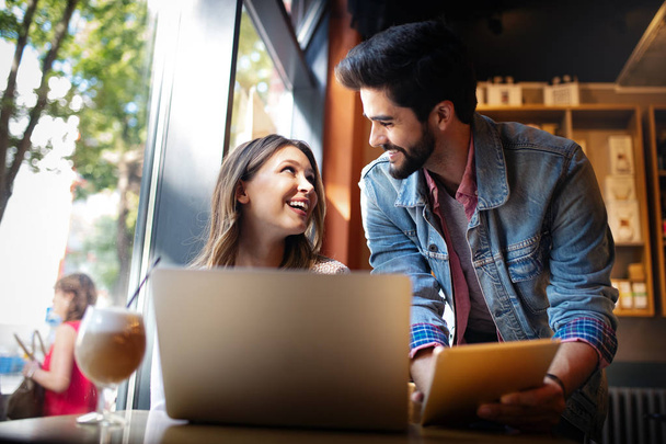 Young happy couple is working in cafe on laptop and smiling. - 写真・画像