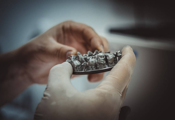 Man holds in hands object printed on metal 3d printer in laboratory. - Fotografie, Obrázek