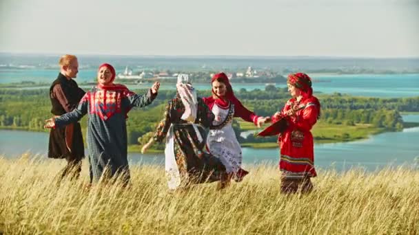 Lidé v tradičních ruských šatech tančí na hřišti hudbou z balalalky - Záběry, video