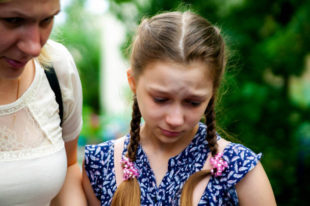 problemas de adolescente - menina adolescente triste chora com sua mãe preocupada no fundo. - Foto, Imagem