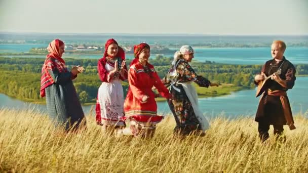 Joven conjunto de ropa tradicional rusa bailando en el campo
 - Imágenes, Vídeo