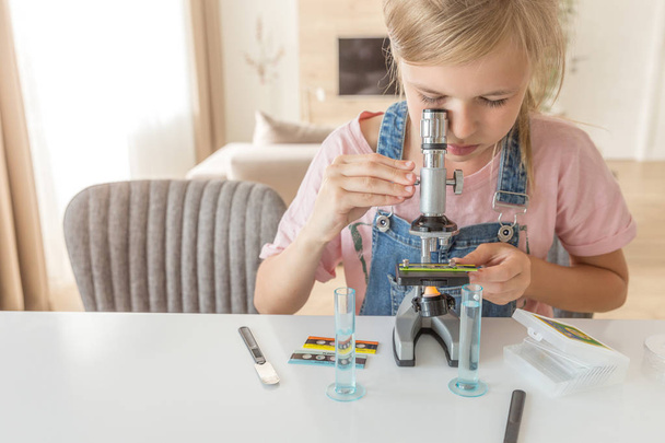 Dziewczyna nauki chemii gry z mikroskopem w domu - Zdjęcie, obraz