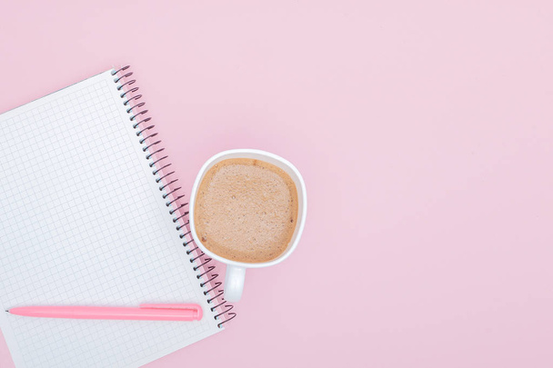 top view business background workspace with coffee, pen and blank notebook on pink background. image for education, desktop, copy space, work, workplace, beverage, mock up concept - Foto, Imagen