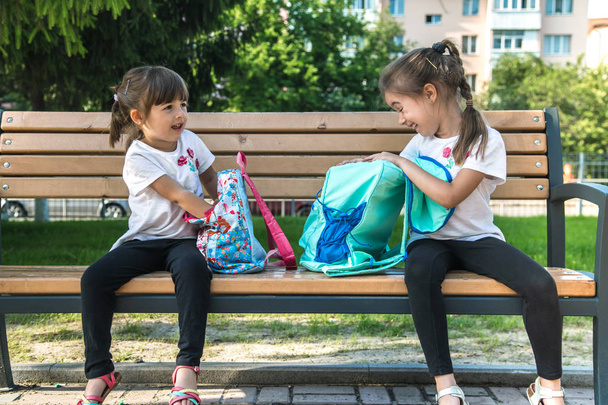 Back to school. Happy cute industrious kids sitting on the bench - Photo, Image