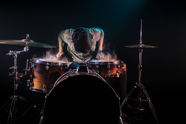 музикант грає на барабанах зі сплесками, чорний фон з красунею
 - Фото, зображення