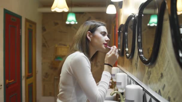 Woman applying lipstick in hostel toilet - Footage, Video