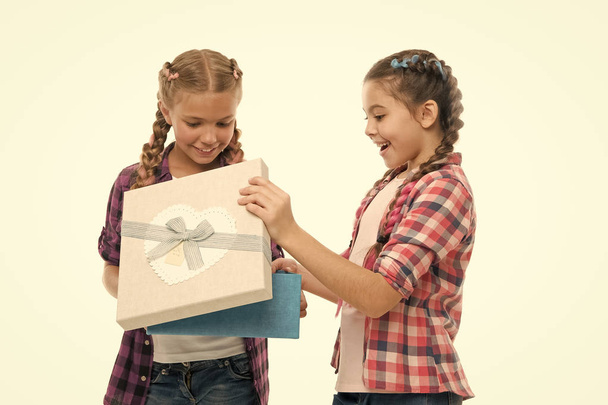 Kids little girls with braids hairstyle hold gift box. Children excited about unpacking gift. Small cute girls sisters received holiday gift. Dreams come true. Best birthday and christmas gifts - Foto, afbeelding