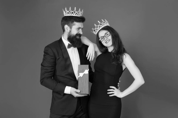Royal traditions. Celebrate anniversary. Royal gift. King in tuxedo golden crown giving gift box to queen of his heart. Couple in love royal family. Elite society. King and queen formal event - Fotoğraf, Görsel