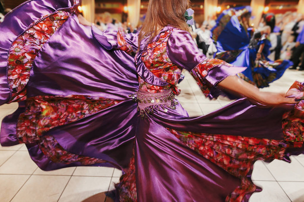 Красивые цыганские девушки танцуют в традиционном фиолетовом цветочном платье
 - Фото, изображение