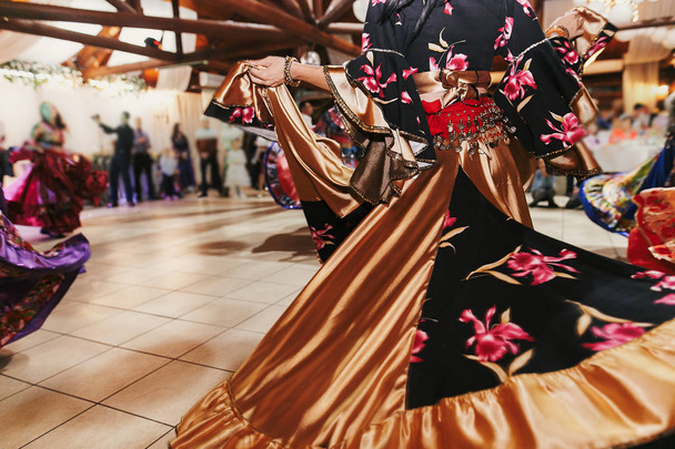 schöne Zigeunermädchen, die in traditionellem goldenem floralen Kleid tanzen - Foto, Bild
