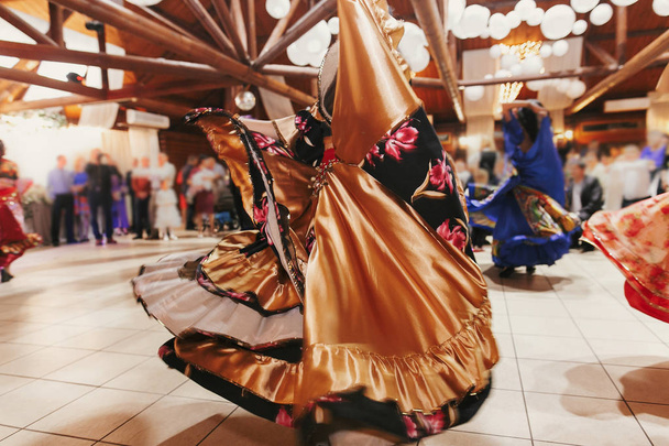 Красивые цыганки танцуют в традиционной красочной одежде
.  - Фото, изображение
