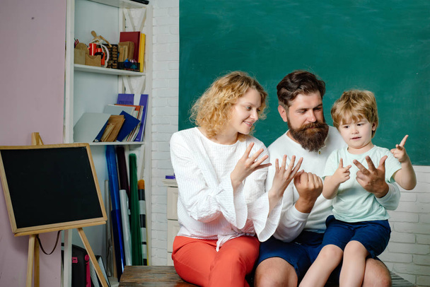 Funny little child with family having fun on blackboard background. Counting on fingers. Family day. School kids. Mathematics for kids. Kids gets ready for school. School family. - 写真・画像