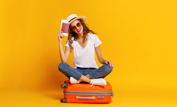 az utazás fogalma. boldog nő lány bőrönddel és útlevéllel  - Fotó, kép