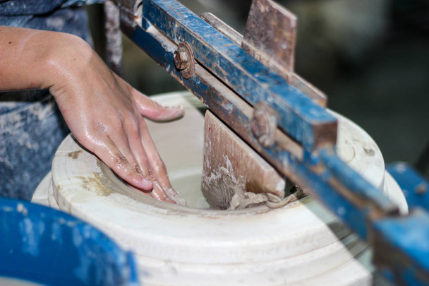 ruce Pottera, který vytváří mísu pomocí terraja, keramické leštění s 2 prsty v posledním kroku. Před vstupem do pece - Fotografie, Obrázek