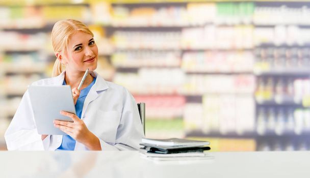 Pharmacist using tablet computer at pharmacy. - Photo, Image