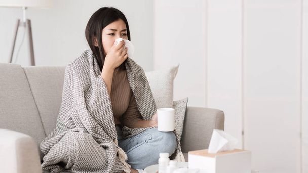 Chica enferma con fiebre envuelta en manta bebiendo té caliente
 - Foto, Imagen