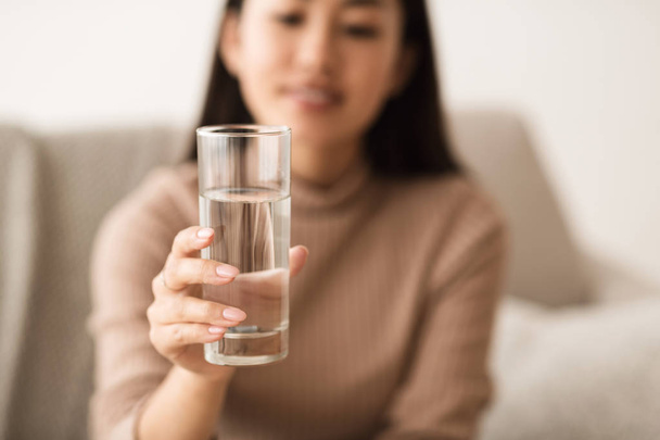 Asiatique fille tenant l'eau minérale dans le verre
 - Photo, image