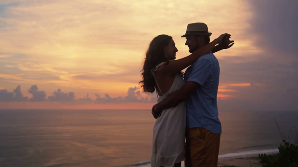 Visão traseira, casal de amantes olhando para o pôr do sol bonito, abraçando, câmera lenta
 - Filmagem, Vídeo