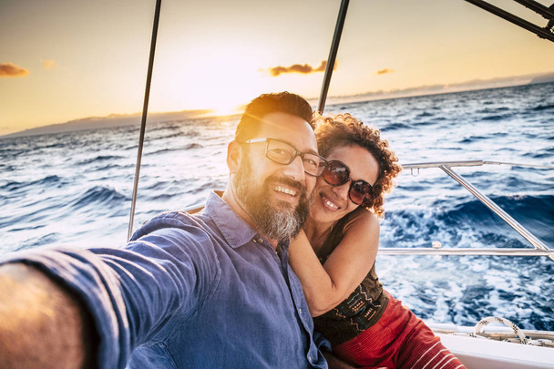 Romantic and happy couple hugging and taking selfie on sail boat  - Photo, Image