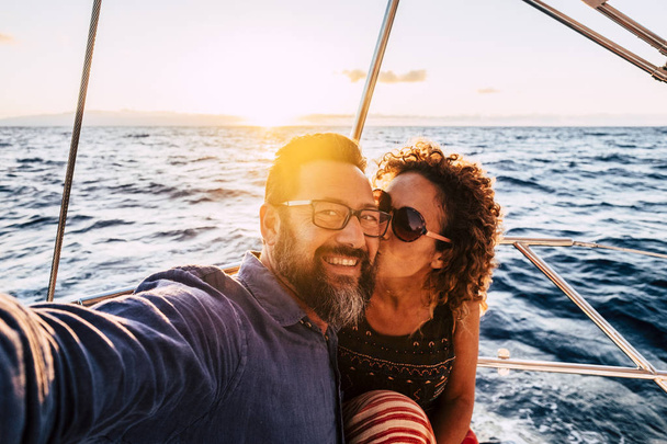 Pareja romántica y feliz besando y tomando selfie en barco de vela
 - Foto, imagen