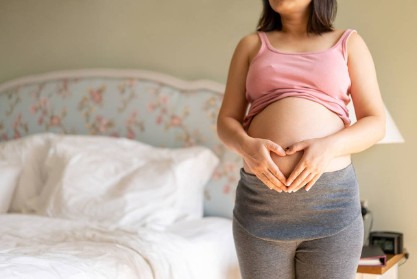 Mujer embarazada feliz y esperando un bebé en casa. - Foto, imagen