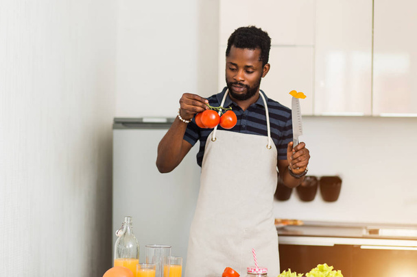 Αφρικανός άνθρωπος προετοιμάζει υγιεινό φαγητό στο σπίτι στην κουζίνα - Φωτογραφία, εικόνα