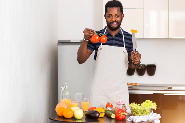 African man preparing healthy food at home in kitchen - Zdjęcie, obraz