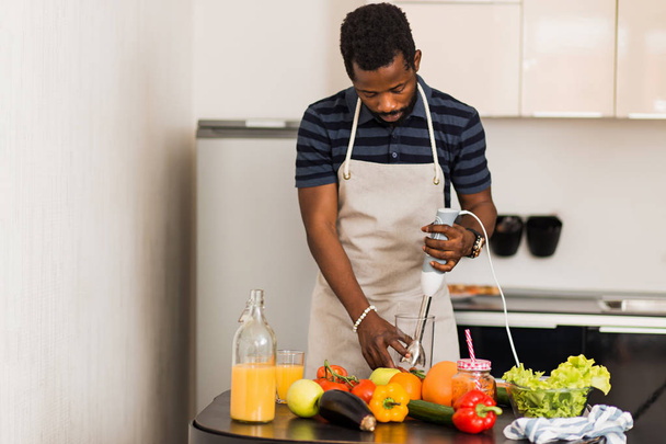 African man preparing healthy food at home in kitchen - 写真・画像