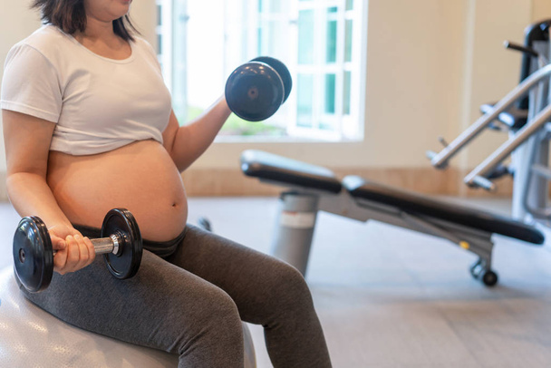 Active pregnant woman exercise in fitness center. - Foto, Imagem