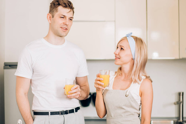Couple making fresh organic juice in kitchen together - Foto, Bild